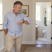 Checking his watch outside the bathroom